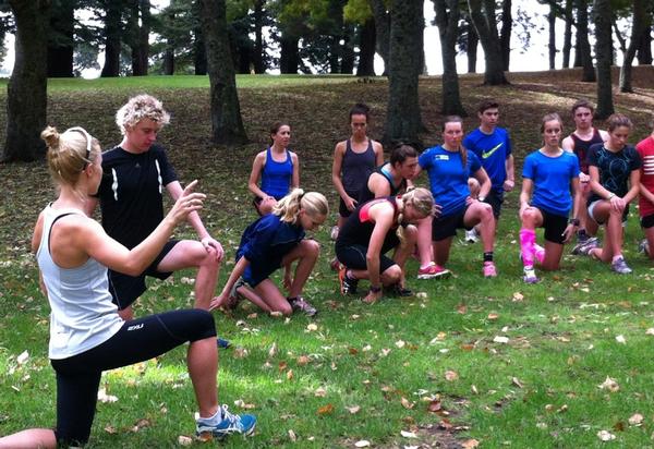 Debbie Tanner (foreground) goes through some pre-run stretching routines with the athletes.  